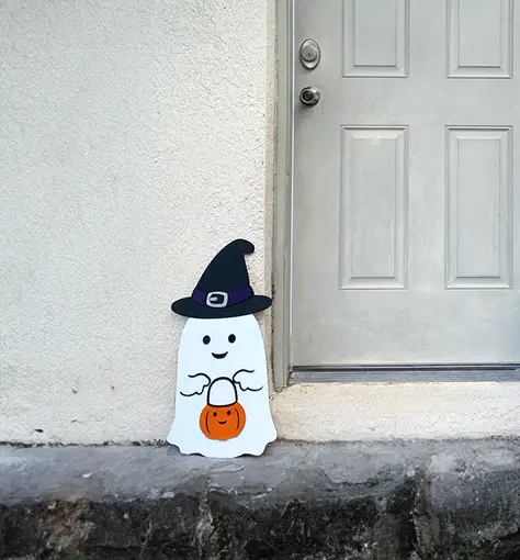 Este fantasma de madera es la manera perfecta de agregar un toque de diversión y misterio a tu decoración de Halloween. Con su sombrero de bruja y su calabaza, es seguro que alegrará a todos los que lo vean.