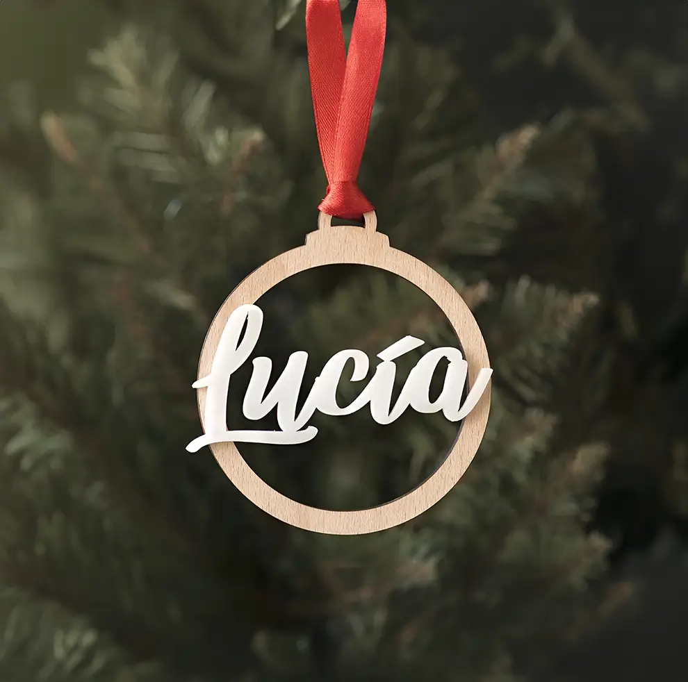 Personaliza el árbol con este lindo recuerdo en forma de circulo y con el nombre: Luía, hecho en madera y un lazo rojo que o sostiene.