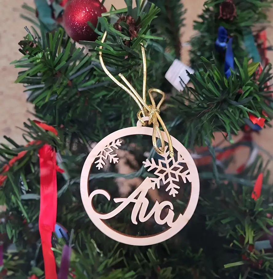 Adorno navideño de madera en forma de círculo, perfecto para regalar en fiestas, cortado con el nombre: "Ava".