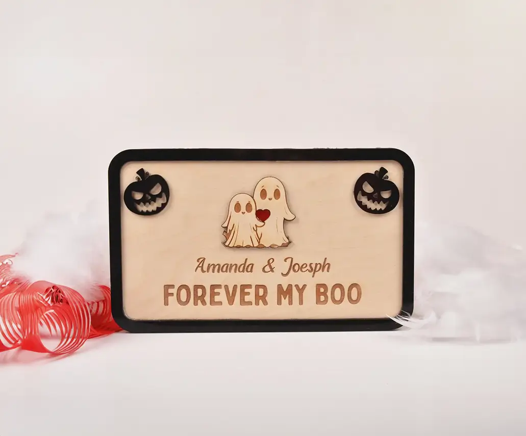 Adorno de madera para Halloween con diseño romántico de dos fantasmas. Perfecto para decorar el hogar o regalar en fechas especiales. Incluye opción de personalización con nombres.