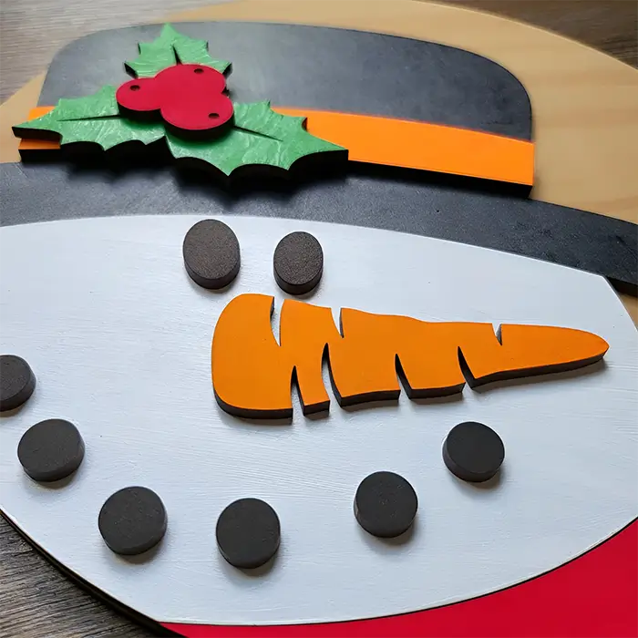 Figura decorativa de un muñeco de nieve navideño, perfecta para añadir un toque tierno a la decoración. El muñeco está hecho de madera y tiene un diseño clásico.