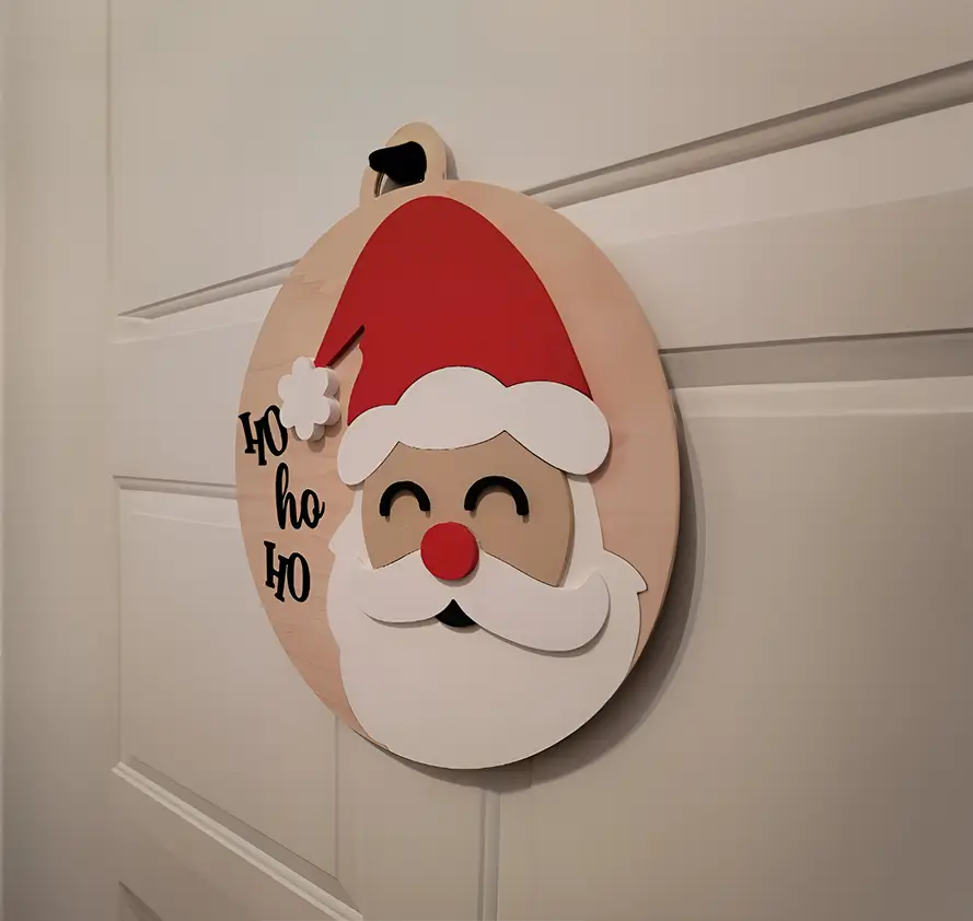 Decoración navideña artesanal: rostro de Santa Claus de madera con una expresión alegre. Perfecta para añadir un toque festivo y divertido a cualquier espacio.