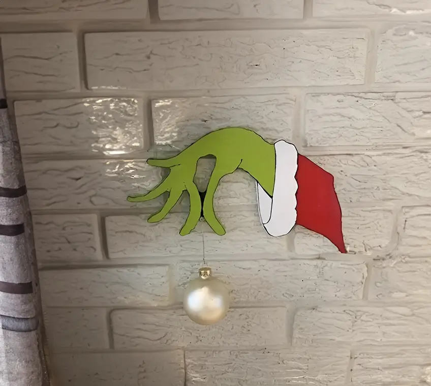 Diseño navideño único con la mano del Grinch en primer plano, resaltando su icónica postura y colores vivos. Perfecto para decoraciones de temporada.
