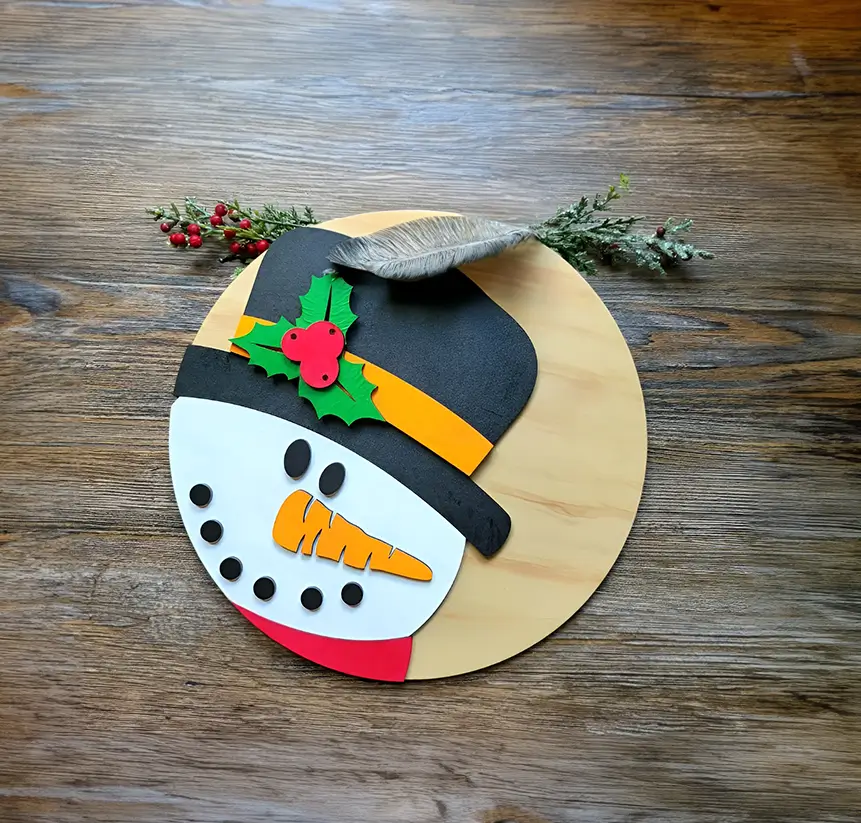 Decoración navideña artesanal: rostro de muñeco de nieve de madera con sombrero y bufanda. Ideal para colgar en la puerta o en el árbol de Navidad.
